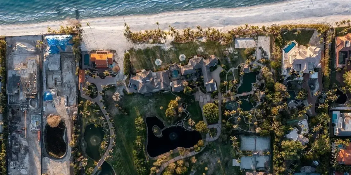Aerial view of luxury beachfront estate on Gordon Drive in Naples, Florida, with gardens, lagoons, and direct ocean access