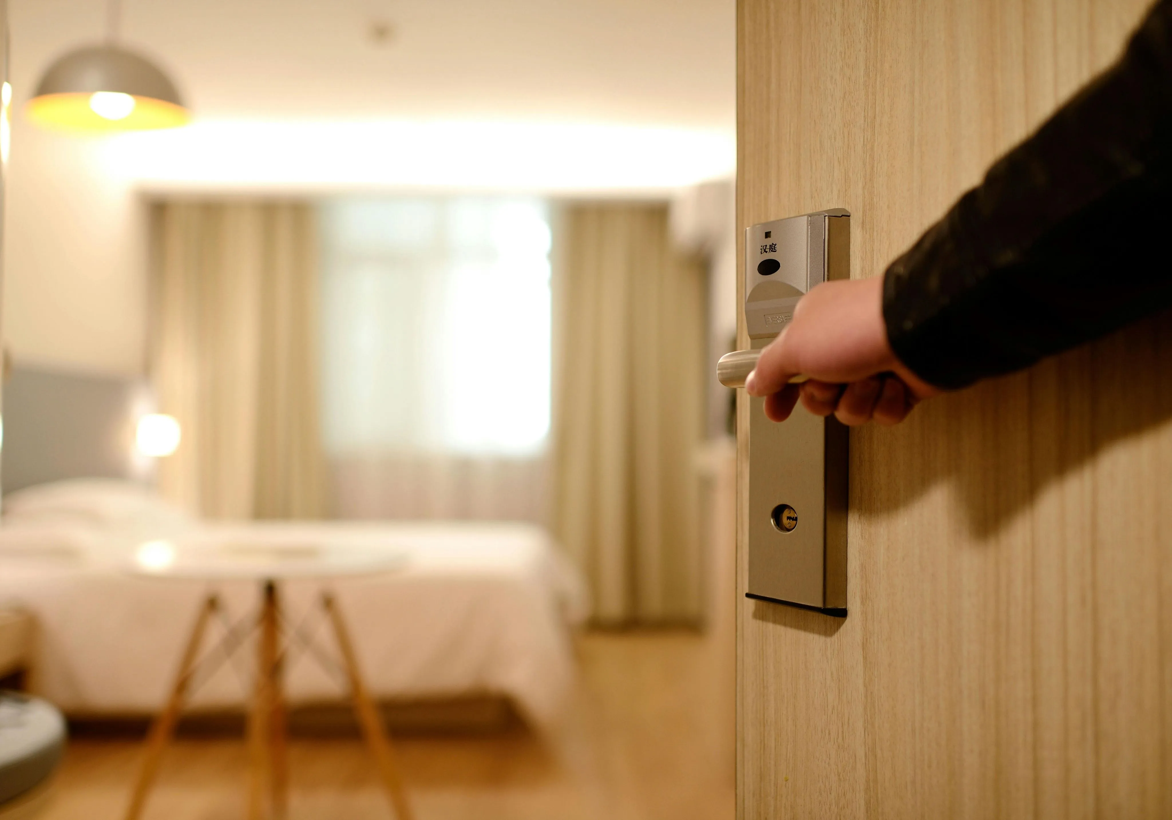 Arrangement of Hostels and Hotels Person Holding on Door Lever Inside Room