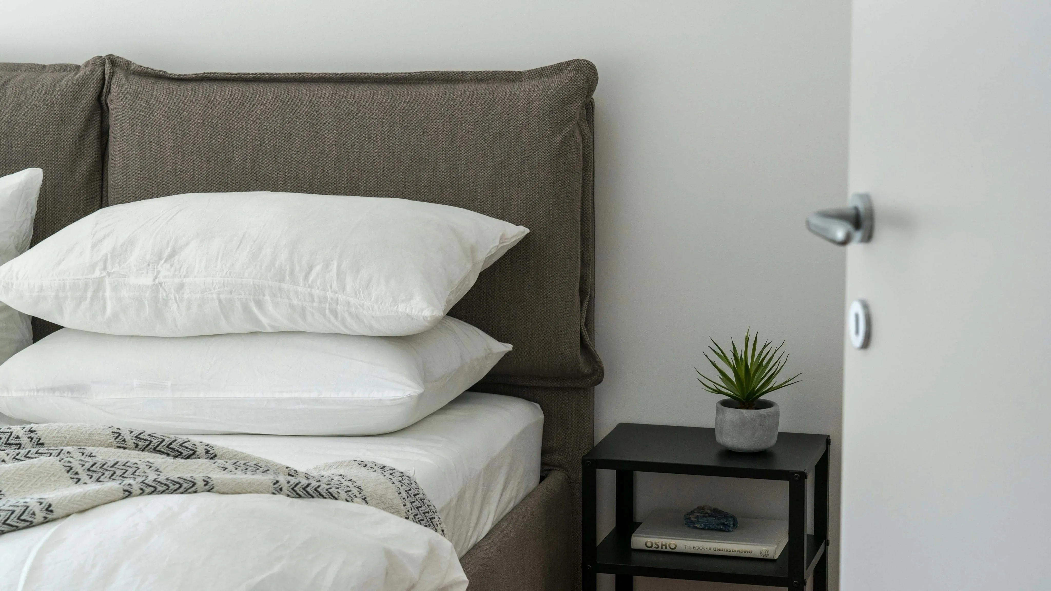A cozy bed with white pillows A cozy bed with white pillows