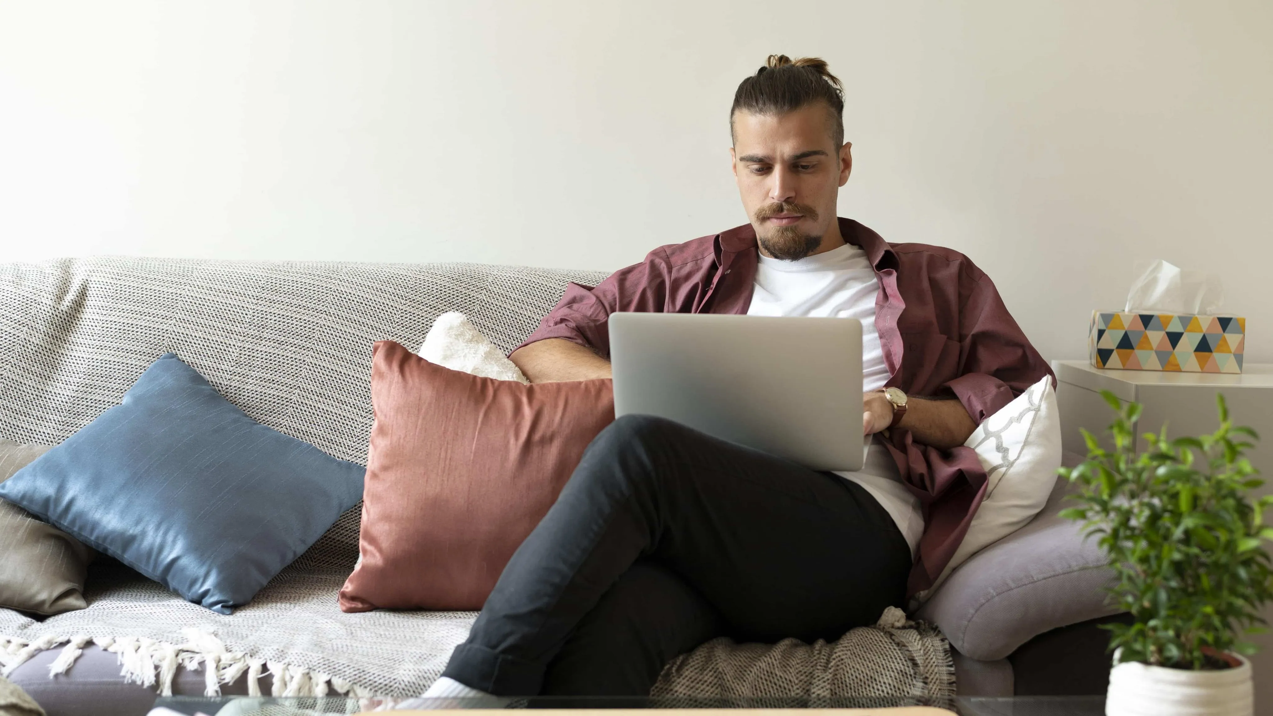 man working with laptop Medium shot man working with laptop on couch