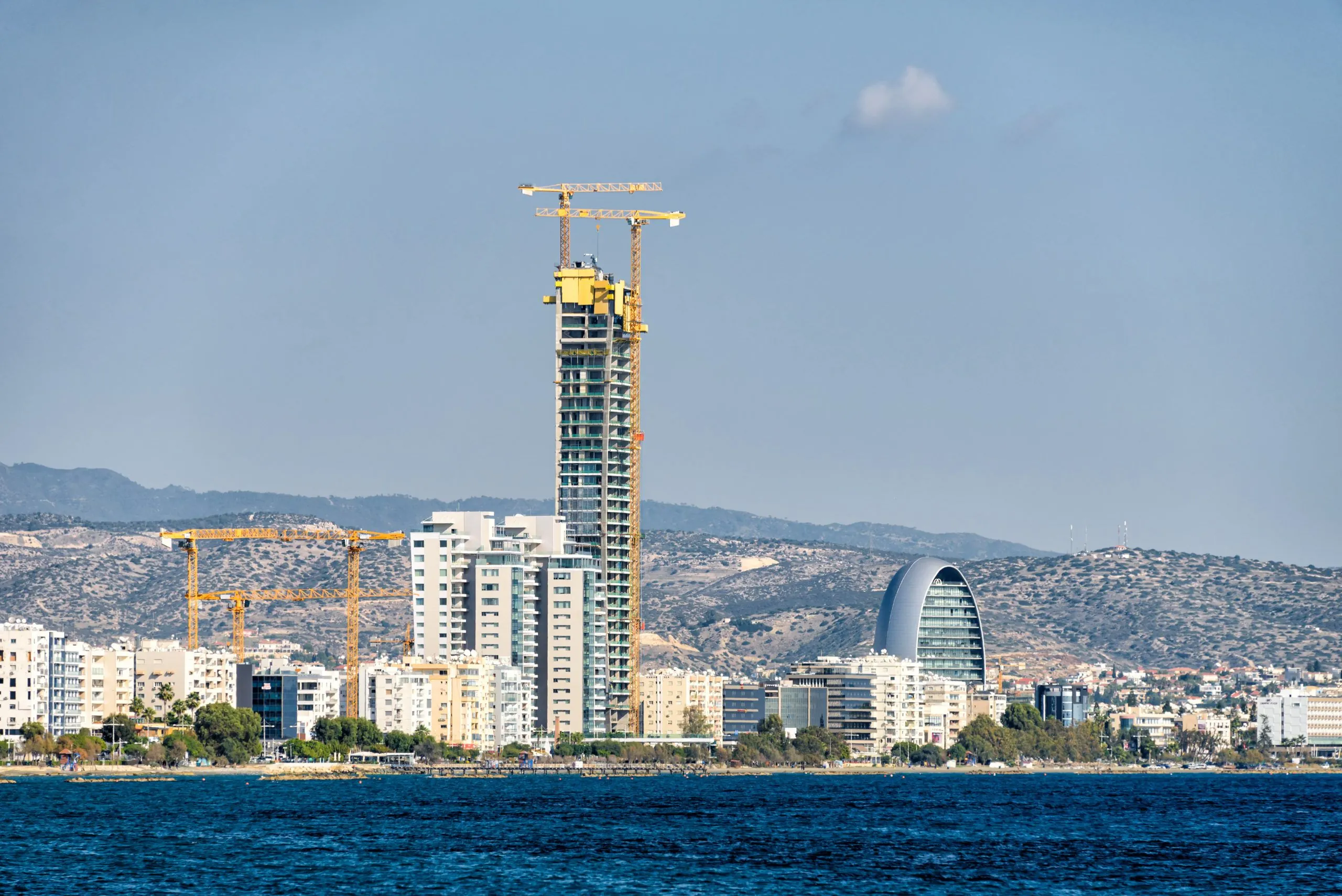 Cyprus Skyscraper Construction A high-rise building under construction in Limassol, Cyprus, with cranes and surrounding cityscape.