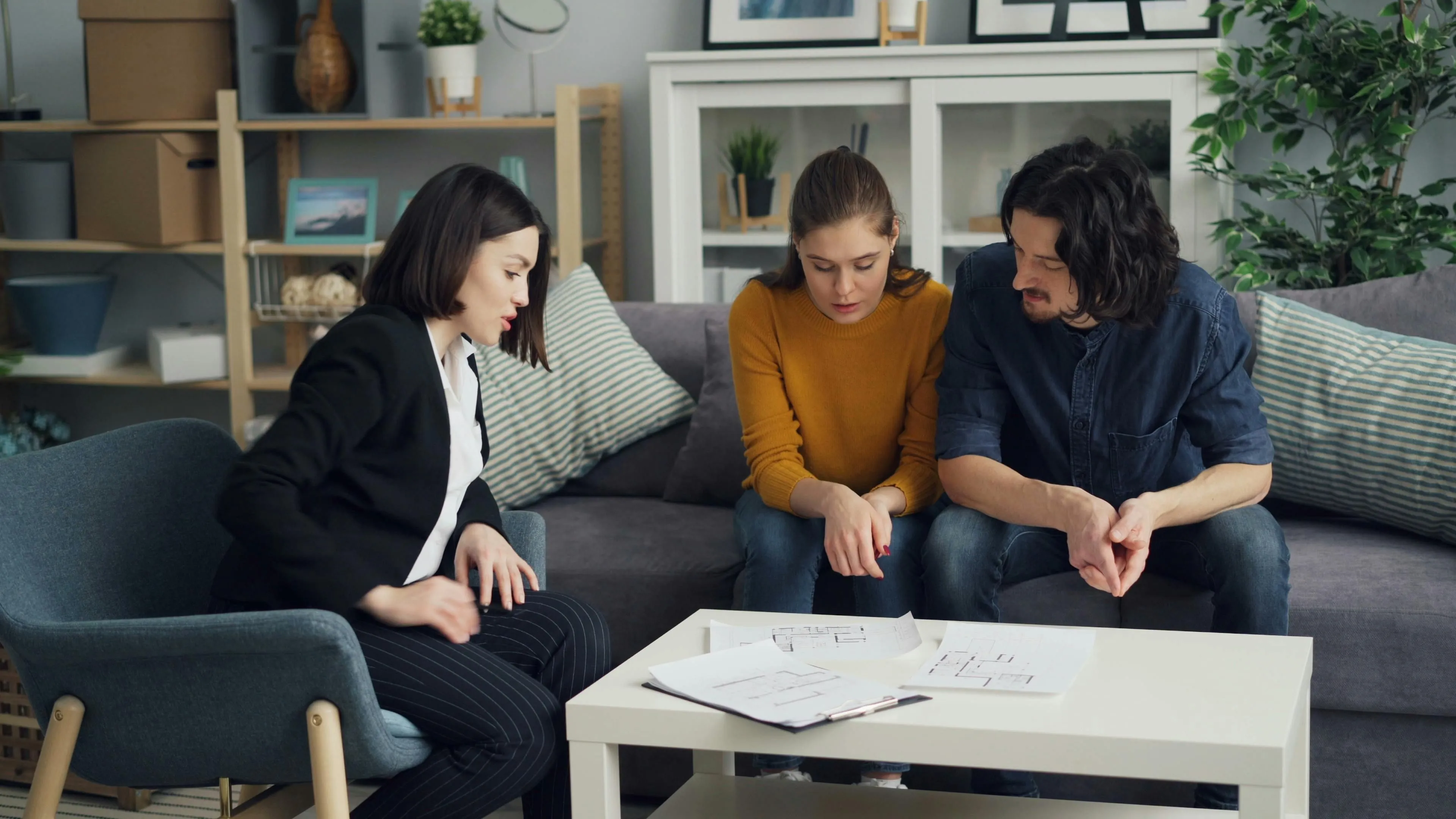 Choosing a Real Estate Agent Real Estate Agent and Couple Sitting at Table