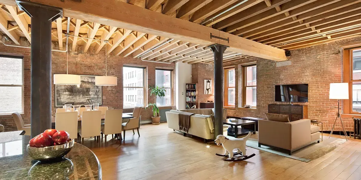 Spacious Tribeca loft interior with exposed brick walls, wood beams, and modern furniture — Taylor Swift’s New York City home
