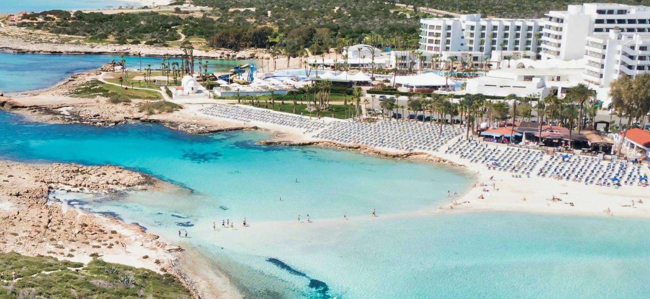 the top Ayia Napa Cyprus restaurants A beach resort with a white hotel and turquoise water in Ayia Napa