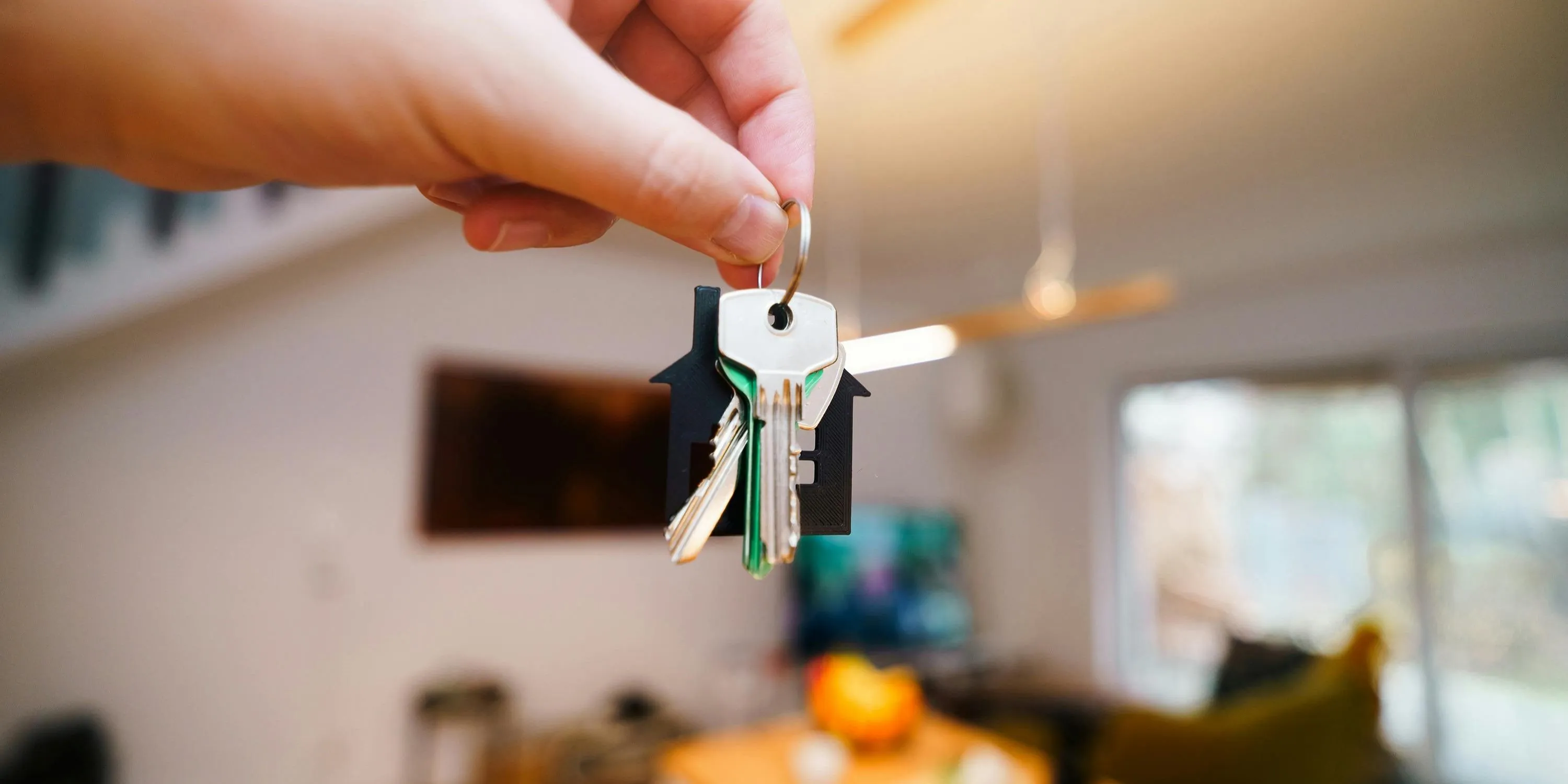Buying a House Hand Holding Keys in Modern Home Interior
