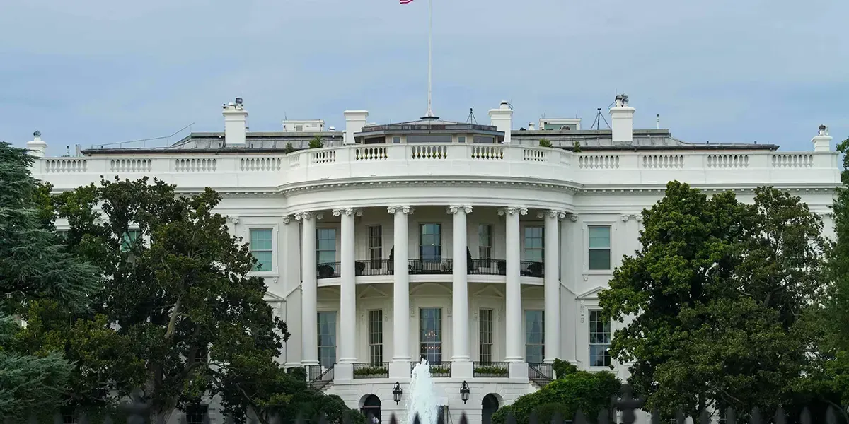 The White House in Washington, D.C., official residence of the U.S. President, surrounded by trees with an American flag on the roof