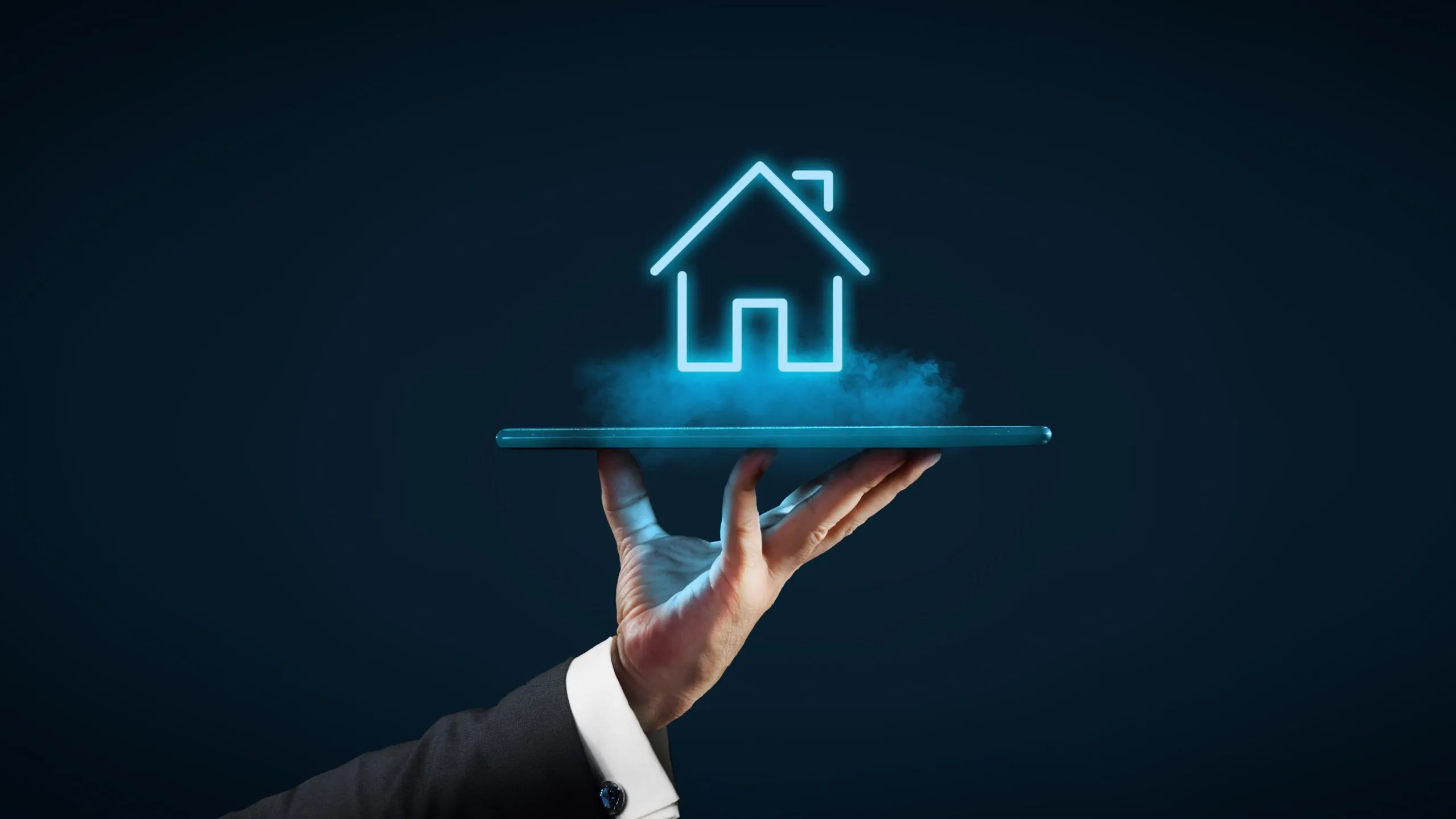 A hand holding a tablet, displaying a glowing neon house icon, symbolizing the intersection of technology and the real estate industry.