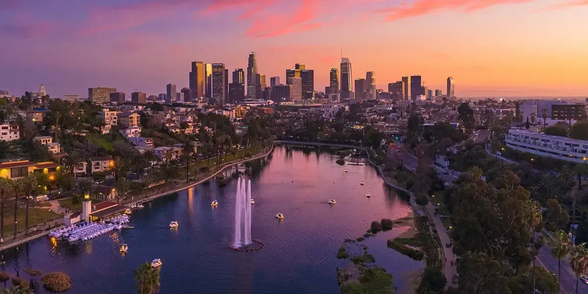 Downtown Los Angeles skyline at sunset with Echo Park Lake and fountain in the foreground